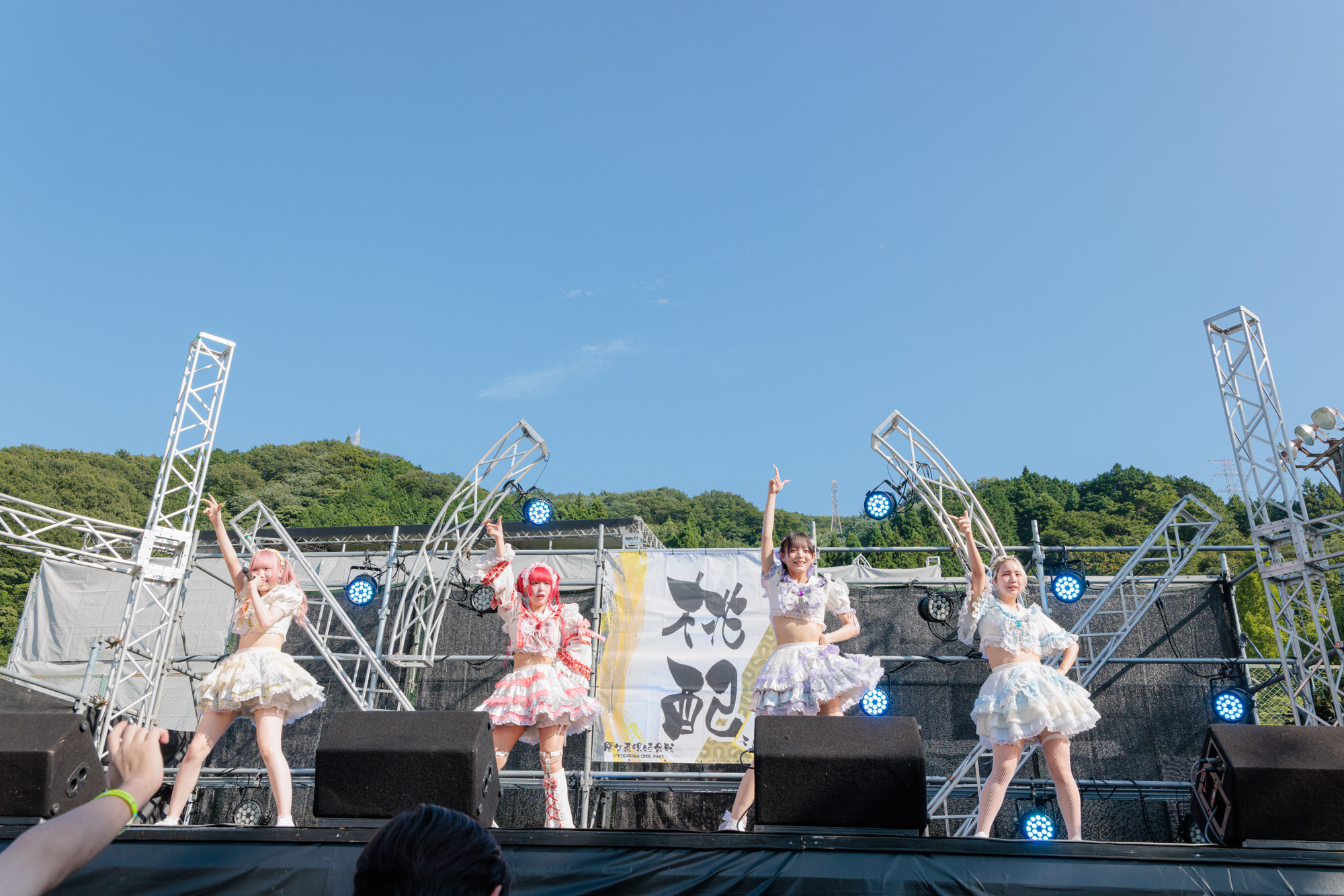 アイドルパフォーマンス - 青空の下での屋外ステージでのエネルギッシュなライブパフォーマンス